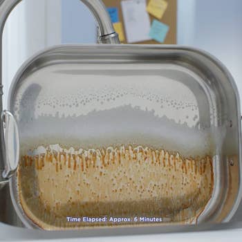 A greased pan soaking in the products suds. The area the soap has run down is shiny and clean. The caption at the bottom reads 