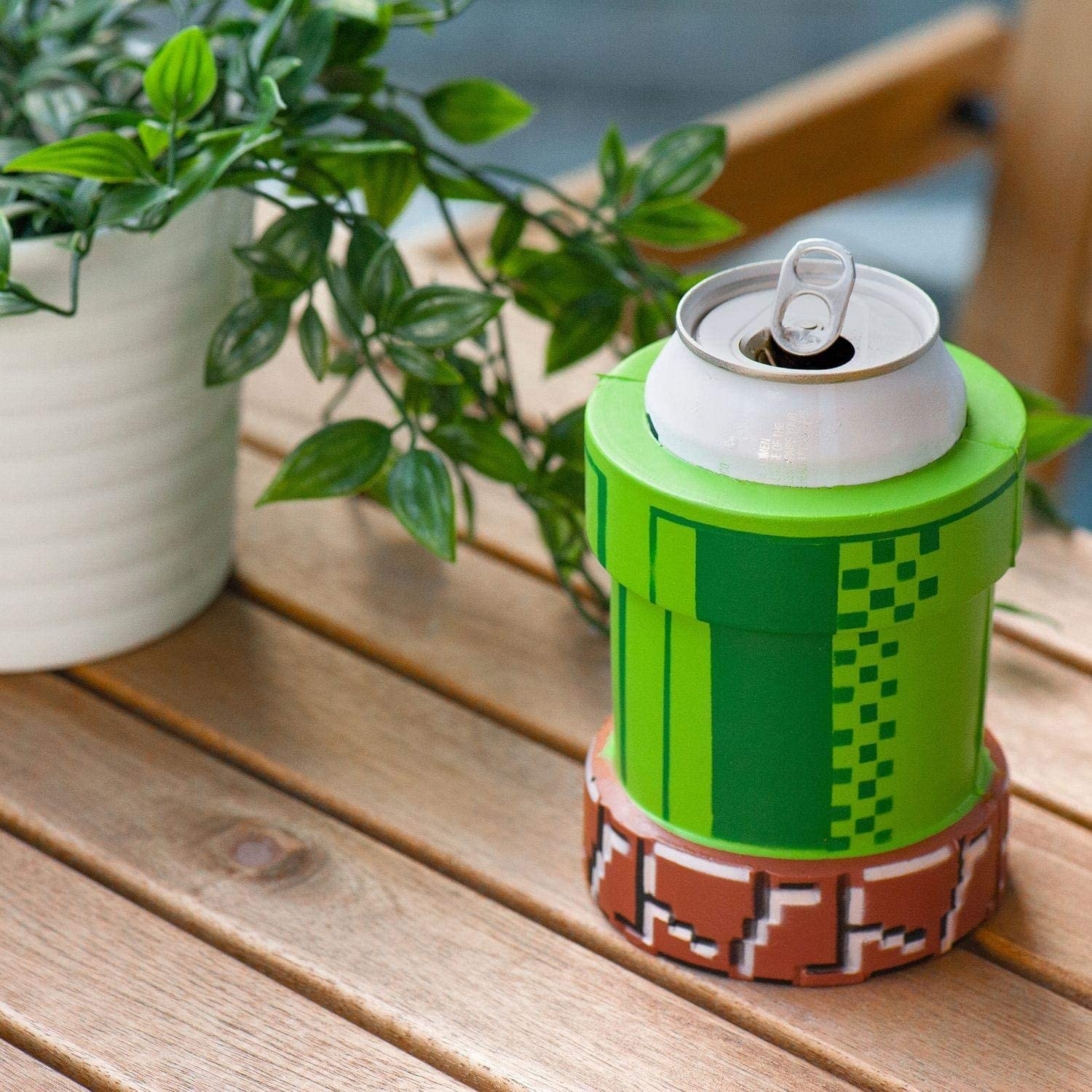 Green and brown "pixelated" coozy in the style of a warp pipe from Mario games