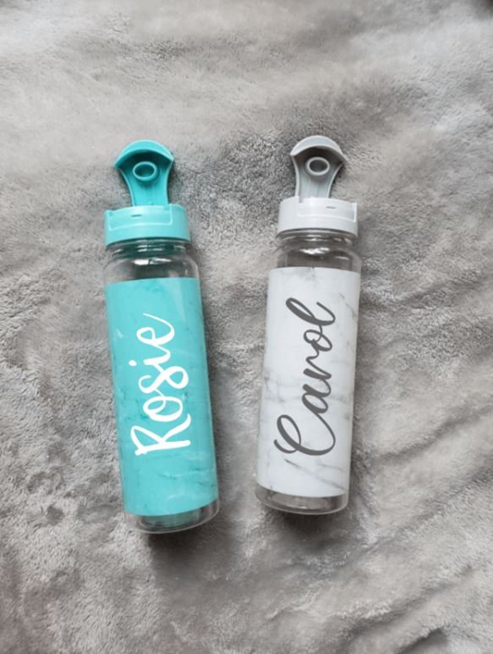 Two water bottles with a customized marble design and people&#x27;s names on them