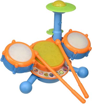 A blue and orange plastic electronic drum kit with drum sticks