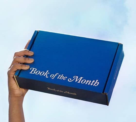 A hand holding the Book of the Month box