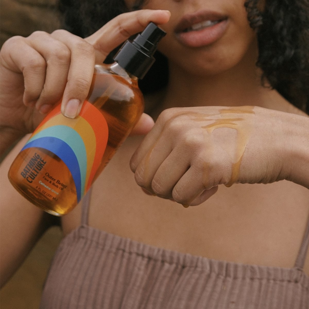 A model dripping the oil over their hand 
