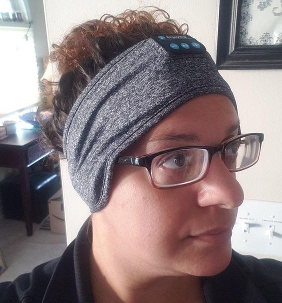 Reviewer wearing the grey stretchy headband with buttons for volume control 