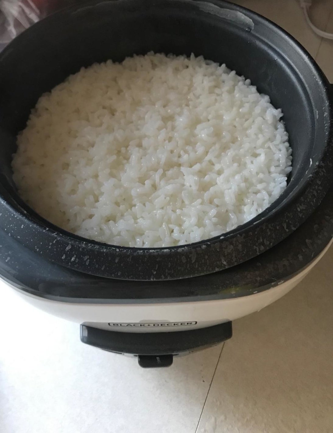 A rice cooker filled with just-cooked white rice. 