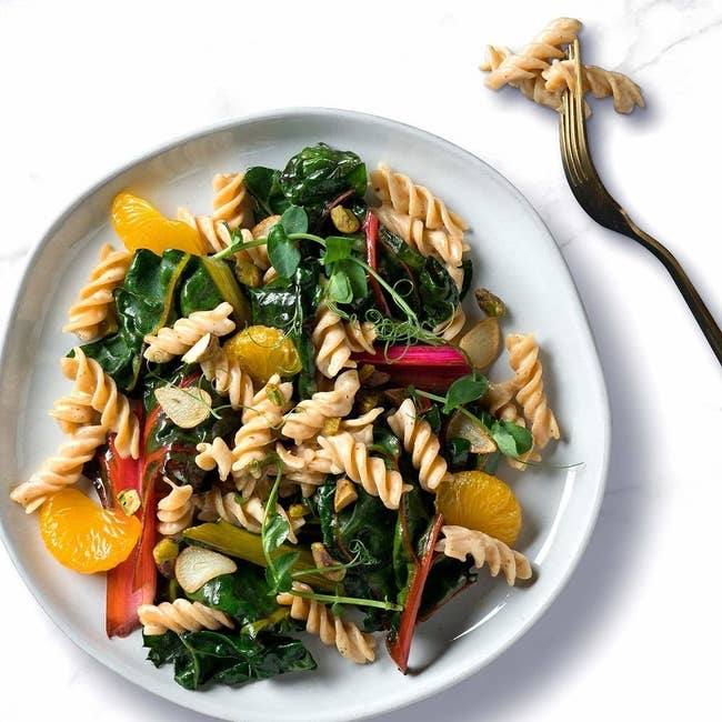 a stock photo of the rotini pasta cooked with spinach, mandarin and rhubarb 