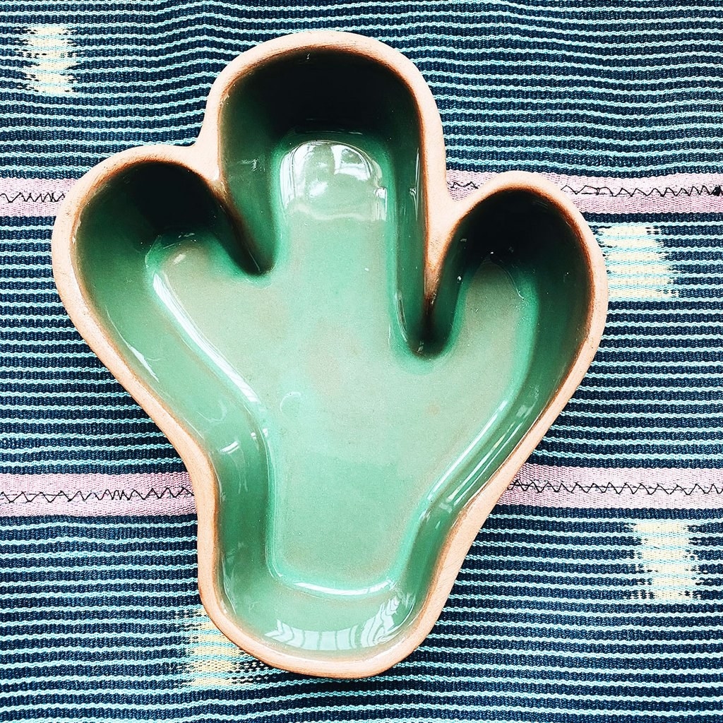 small terracotta dish shaped like. cactus painted green inside