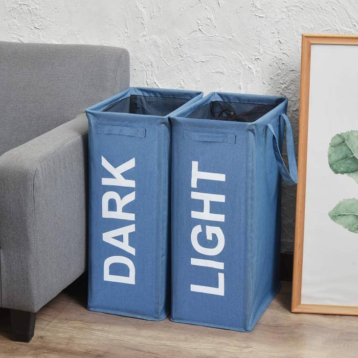 Laundry hampers labelled &quot;Dark&quot; and &quot;Light&quot; beside a sofa
