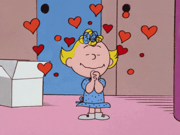 Sally from &quot;Peanuts&quot; with her hands clasped together and eyes closed, surrounded by hearts