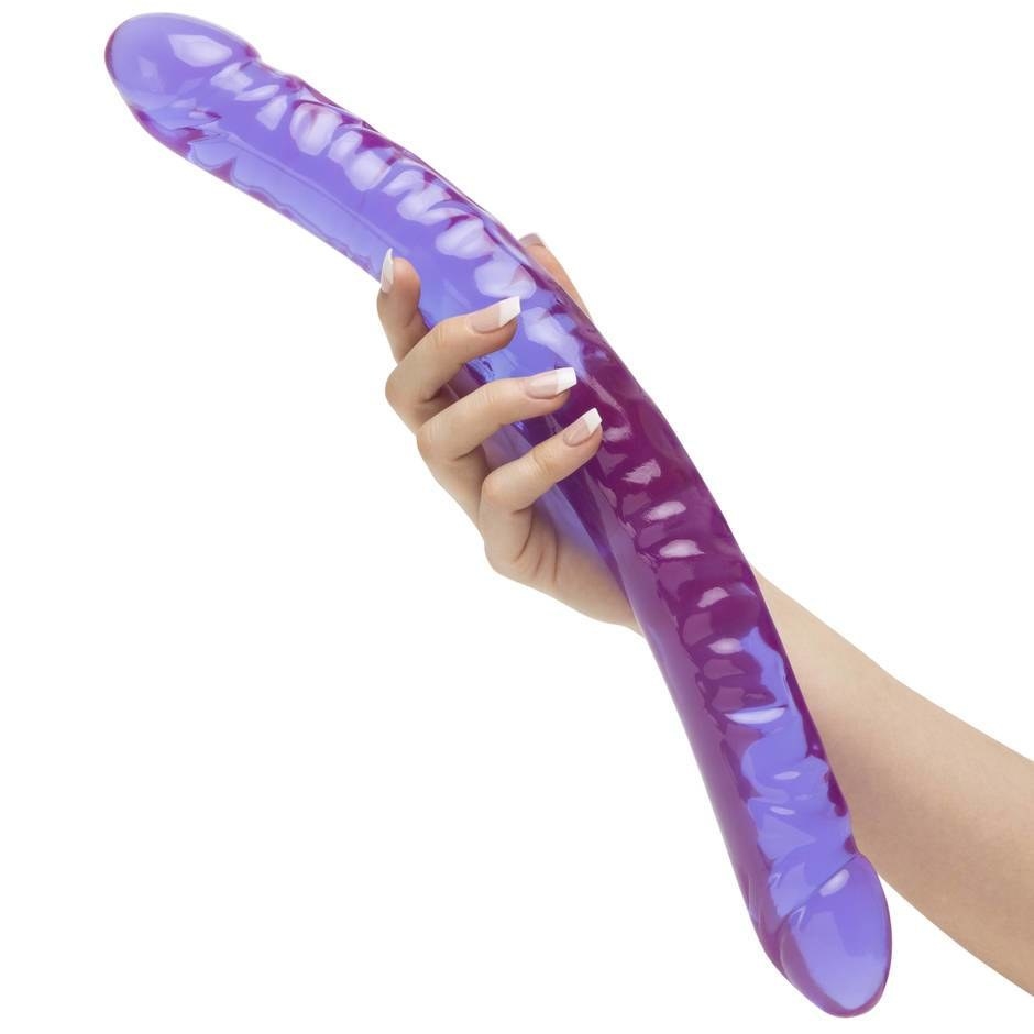 person holding a purple jelly look long double ended dildo