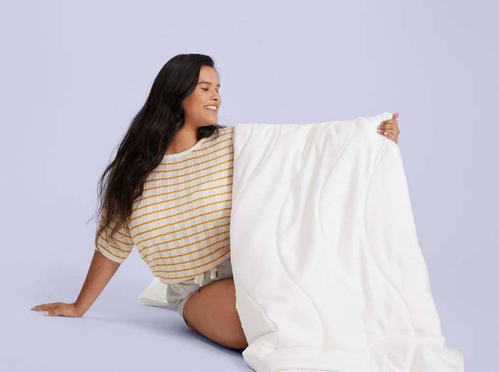 model holds up the comforter 