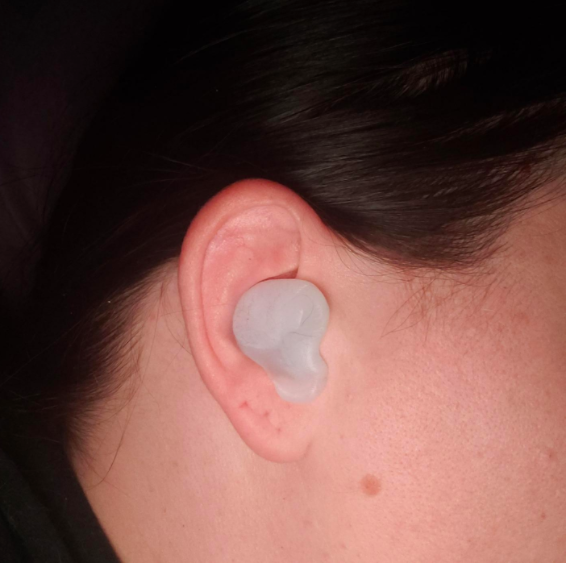 A reviewer&#x27;s ear with the white putty plugs covering the opening