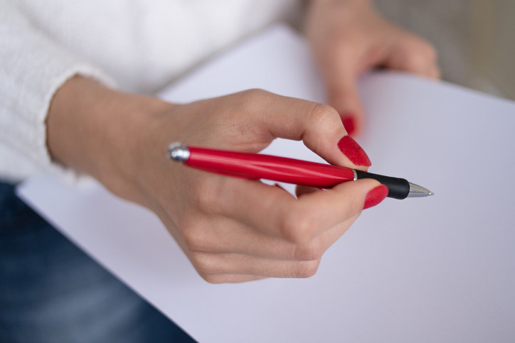 woman holding a red pen