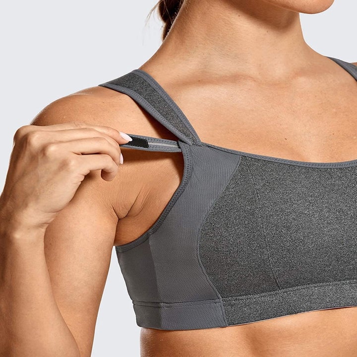 model adjusting the strap on the grey sports bra 