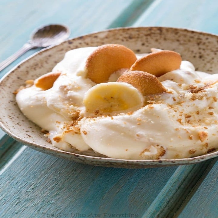 A bowl with a scoop of banana pudding, topped with sliced banana and Nilla wafers.