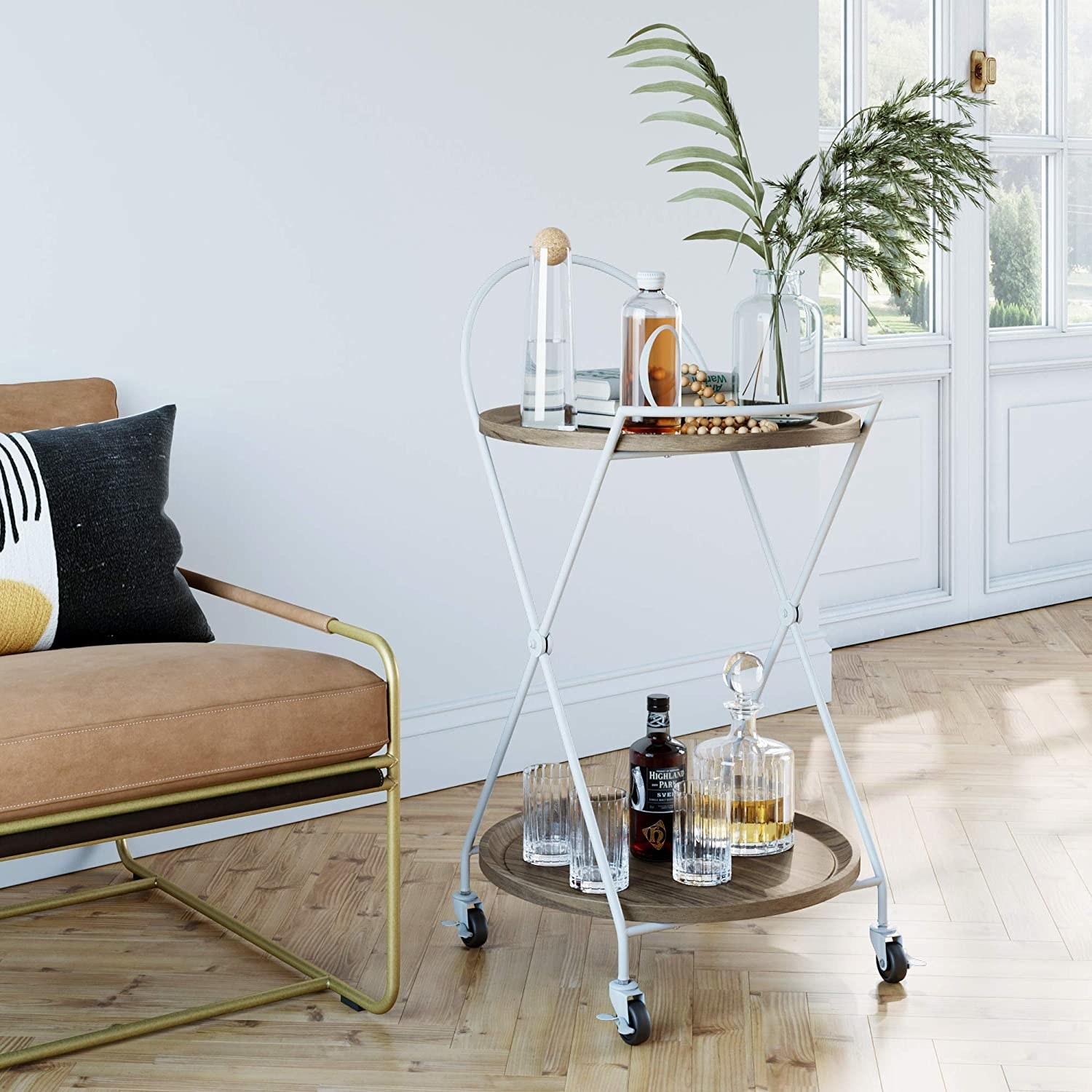 The bar cart in white with criss-cross legs and four wheels