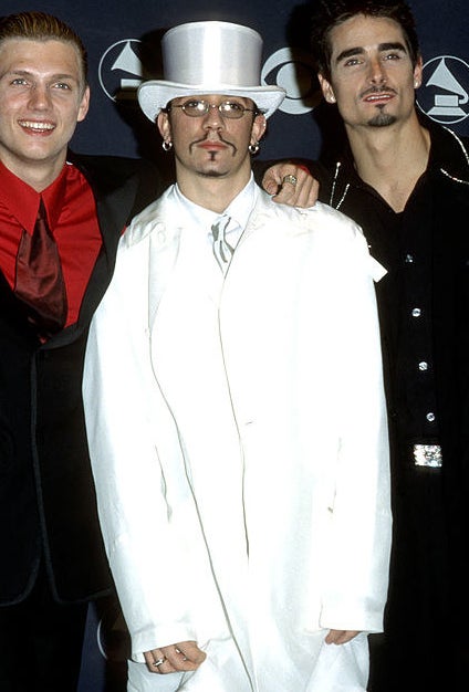 AJ McLean wearing an oversized white suit being surrounded by the other Backstreet Boys