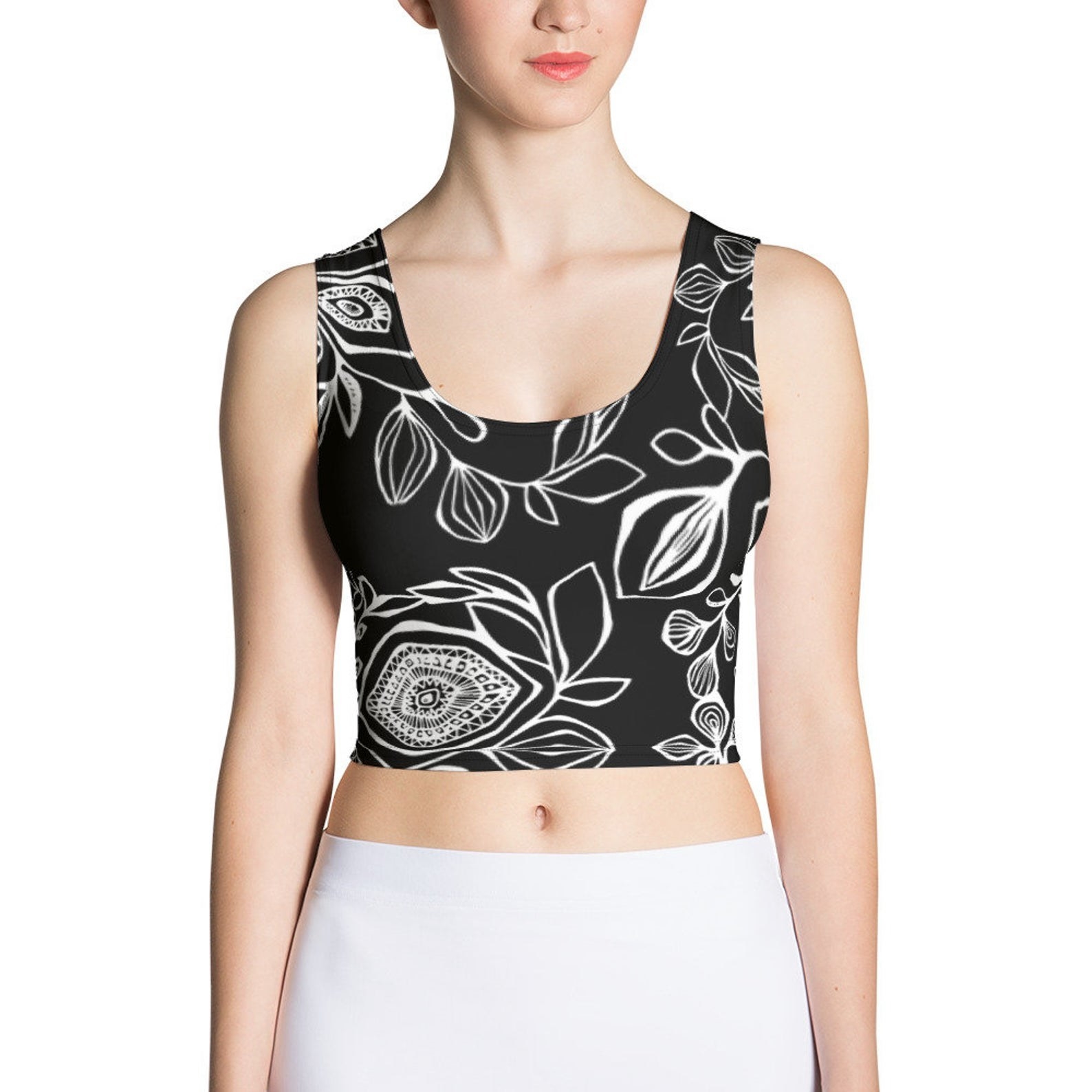 A model in a black crop top with white floral patterns