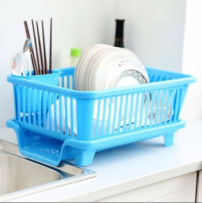 A blue dish drying rack by the sink 