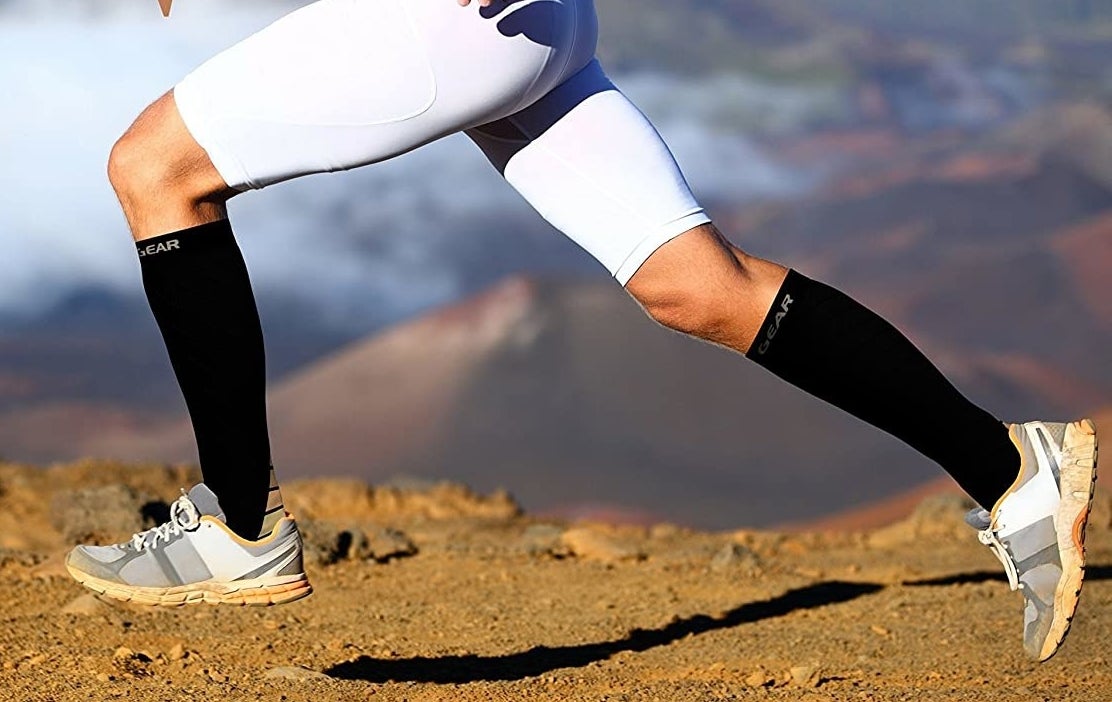 A person running on a dirt road while wearing the compression socks and shorts