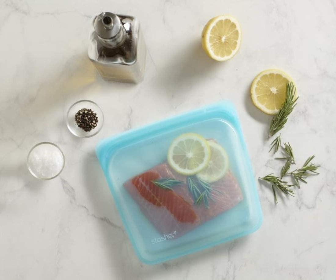 The silicone bags with a salmon filet, herbs, and lemon
