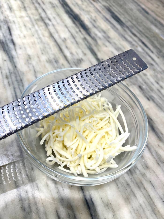 Freshly grated mozzarella cheese from a microplane grater.