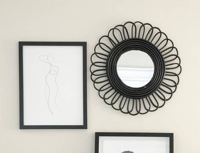 Line art print that looks like a model wearing a hat with a black frame as part of a gallery on a wall