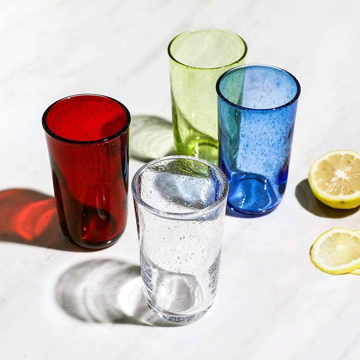 Set of glasses with small bubbles in the glass in clear, red, blue, and green