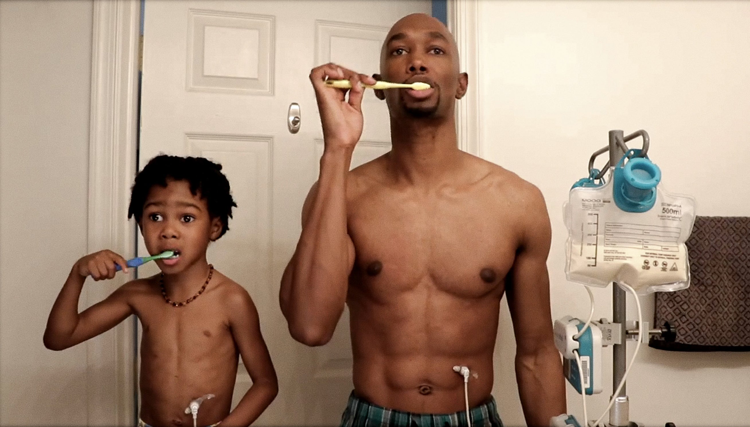 A father and son brushing their teeth.