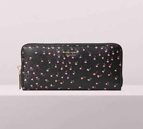 a black elongated rectangle wallet with a zip-around closure and tiny pink flowers all over it