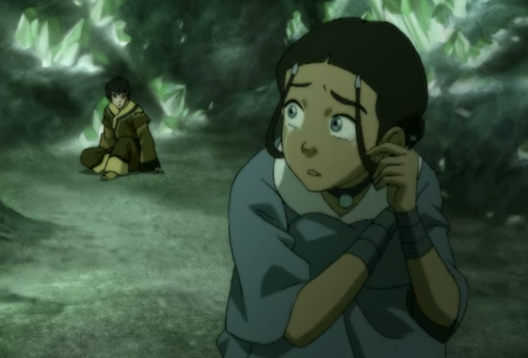 Katara crying while looking back at Zuko in a cave.