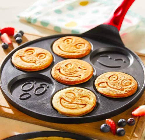 Emoji pancake griddle with smiley pancakes on a table