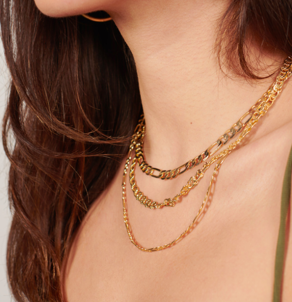 A model wearing the layered gold chain necklaces. 
