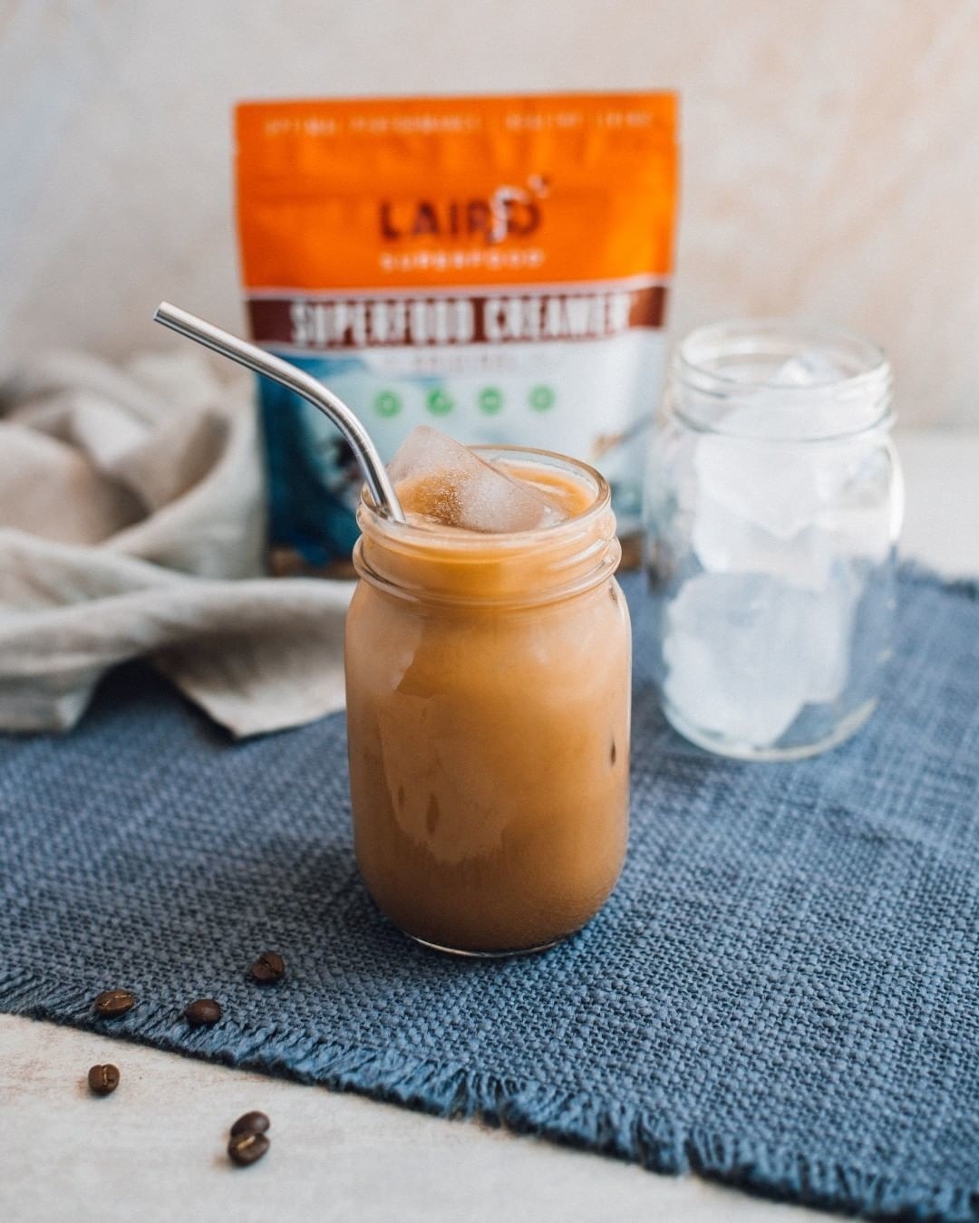 iced coffee in a mason jar with the package of laird superfood creamer behind it out of focus