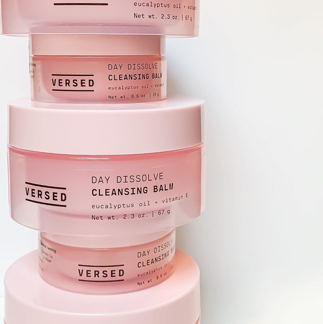 light pink, glass, circular containers of the product stacked on top of one another artfully