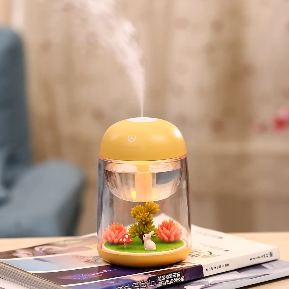 A mini humidifier on top of a stack of magazines