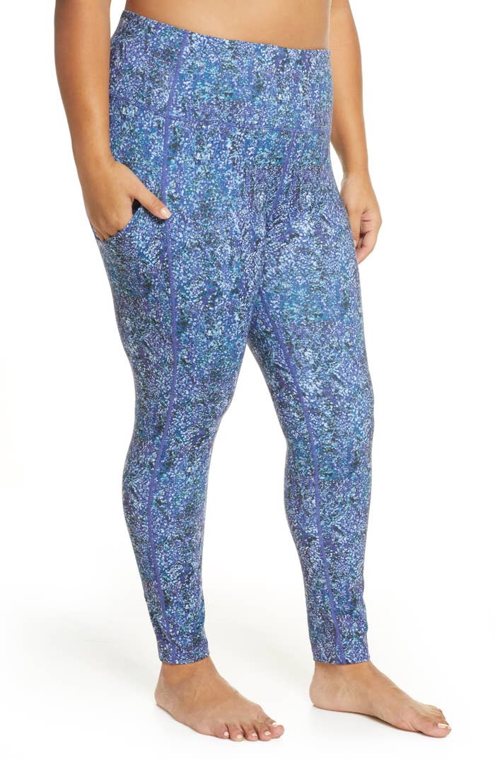 plus size model wearing high waist workout leggings in blue spotted snake print