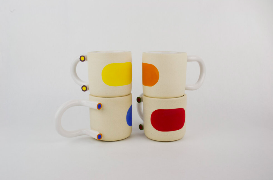 Four colorful mugs stacked two by two 