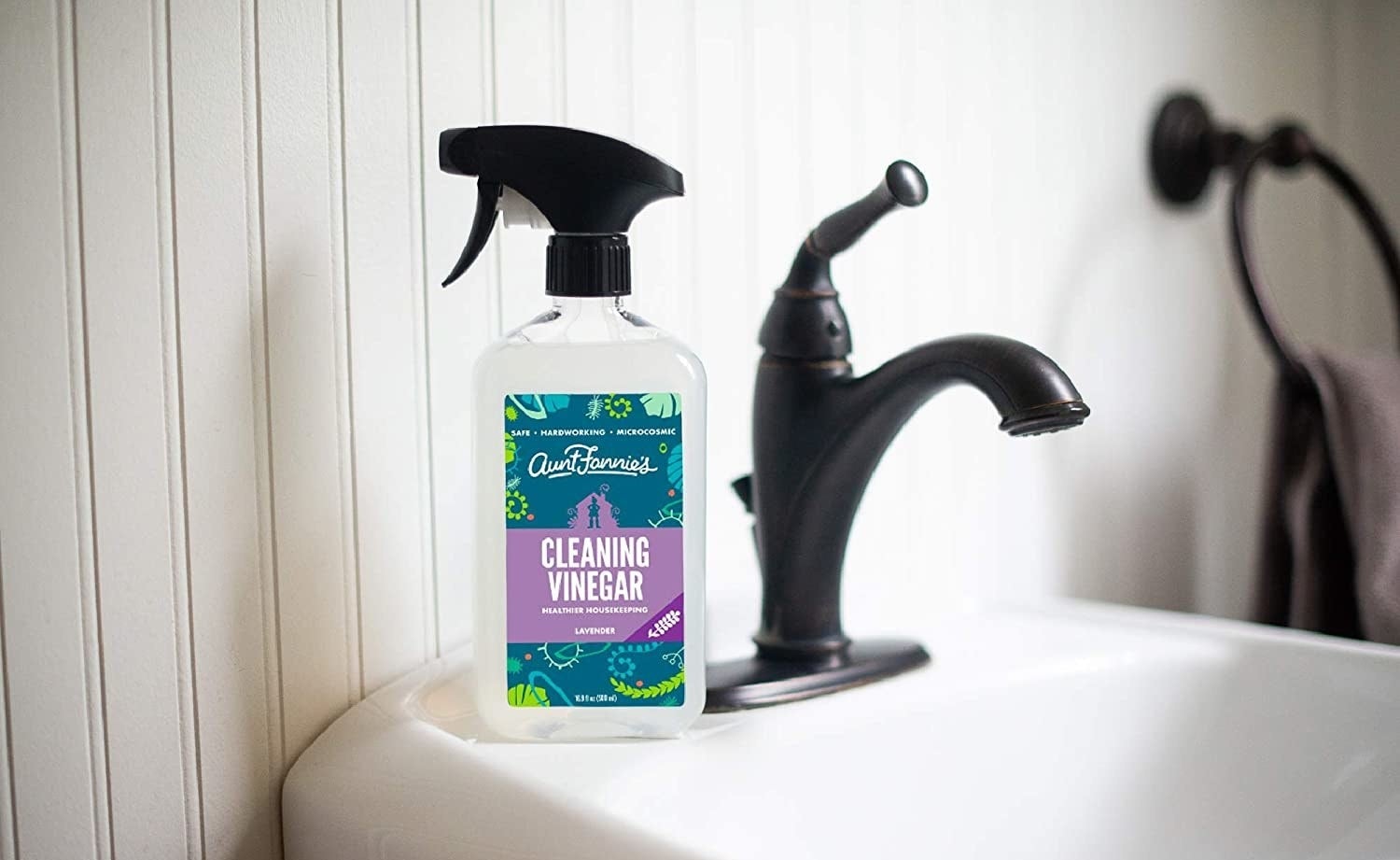The cleaning vinegar sitting on a bathroom sink