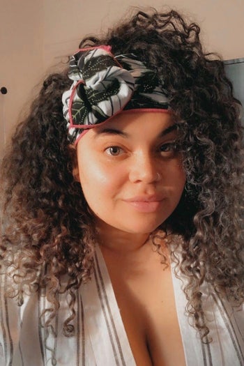 BuzzFeed Shopping editor with a green, white, and pink floral wrap in her curly hair 