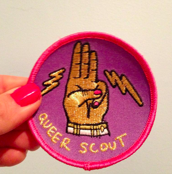 Hand holds same patch against a wall