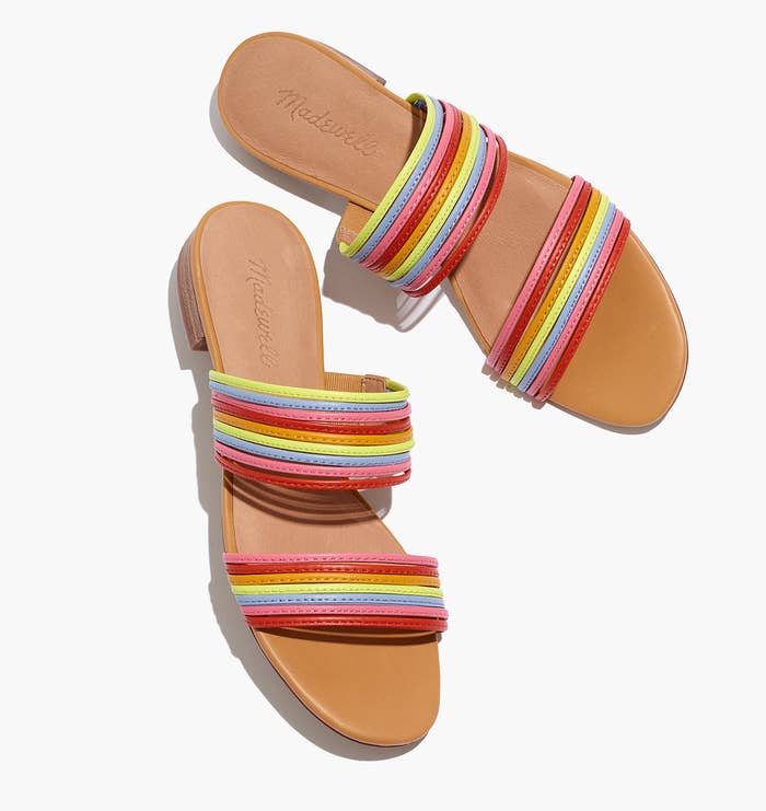 The slides with two sets of thin straps across the footbed in different rainbow colors