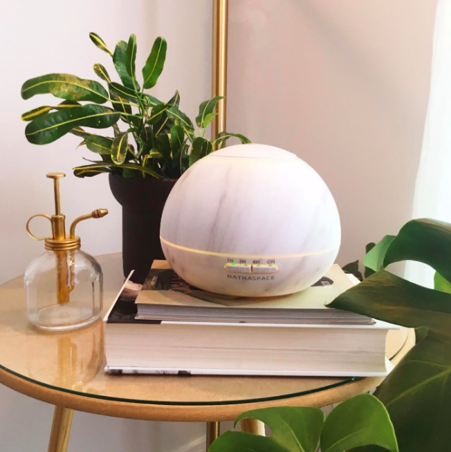 Orb-shaped marble-style diffuser sitting on end table