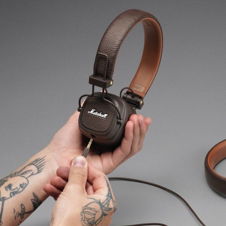 hand holding dark brown leather headphones 