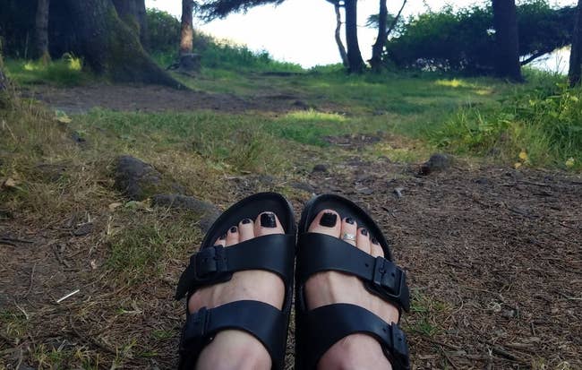 Reviewer wearing the sandals in black outside