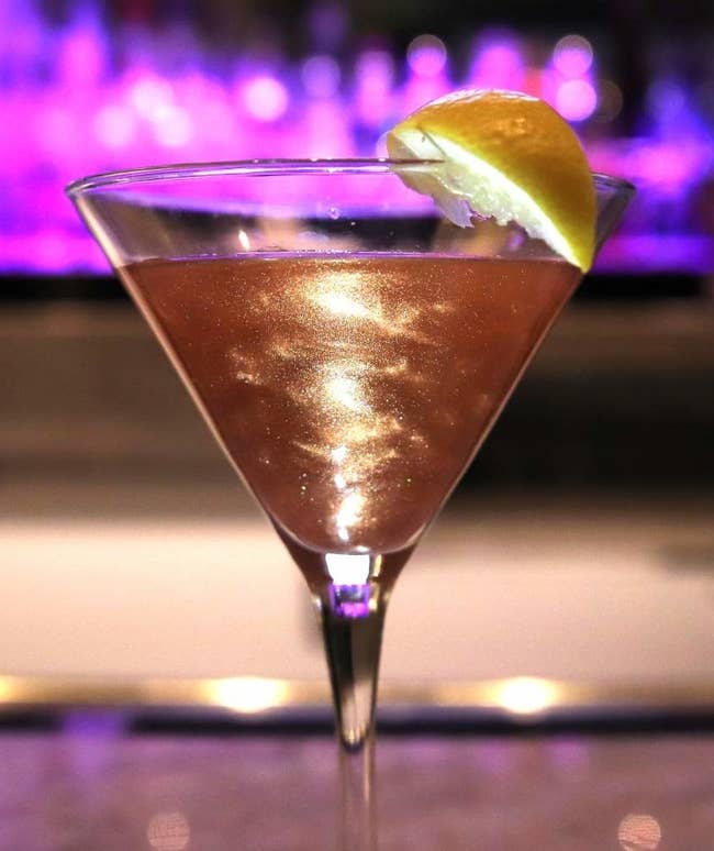 A martini glass filled with sparkling rose gold liquid 