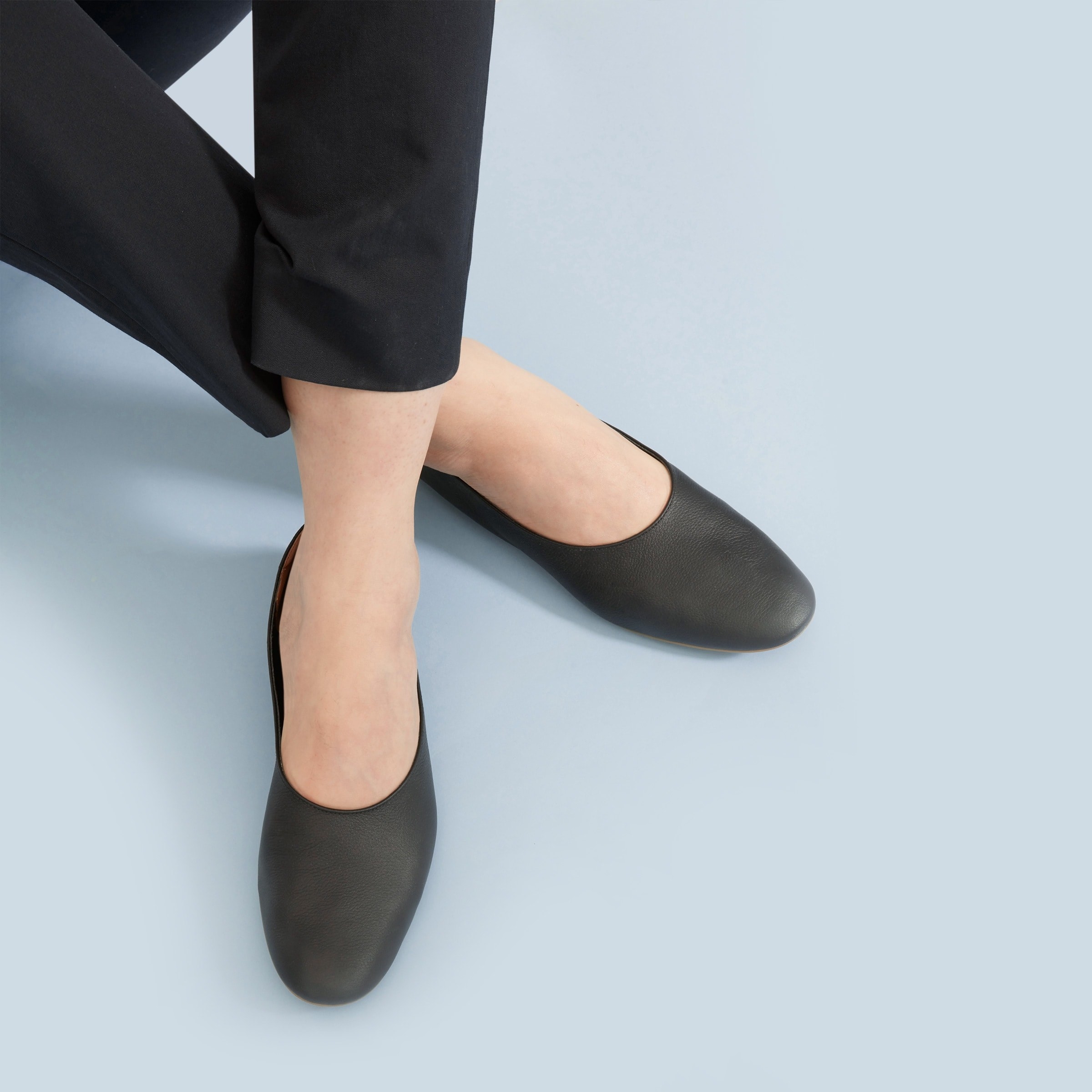 Model wearing the flats in black showing off the rounded toe