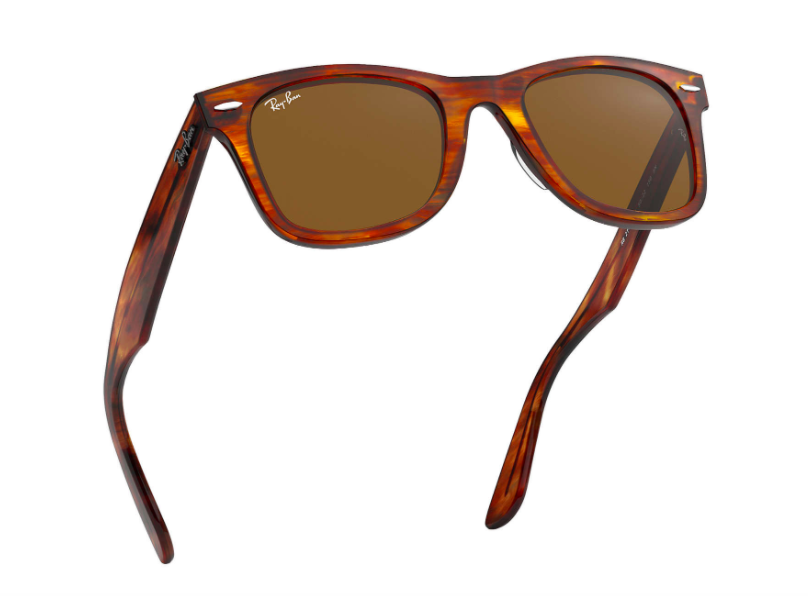 A pair of tortoiseshell Ray-Ban sunglasses in mid-air