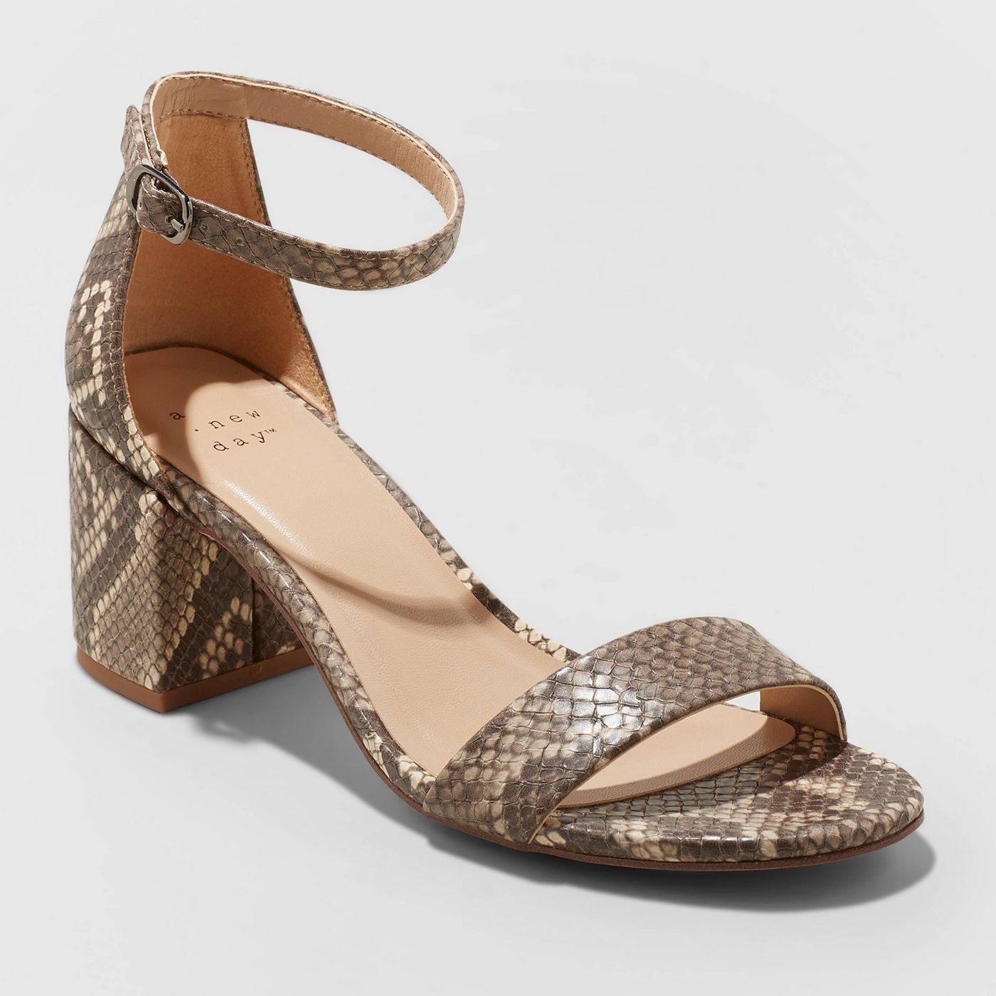 Side view of the sandal with a small block heel and ankle strap in a brown snake-print