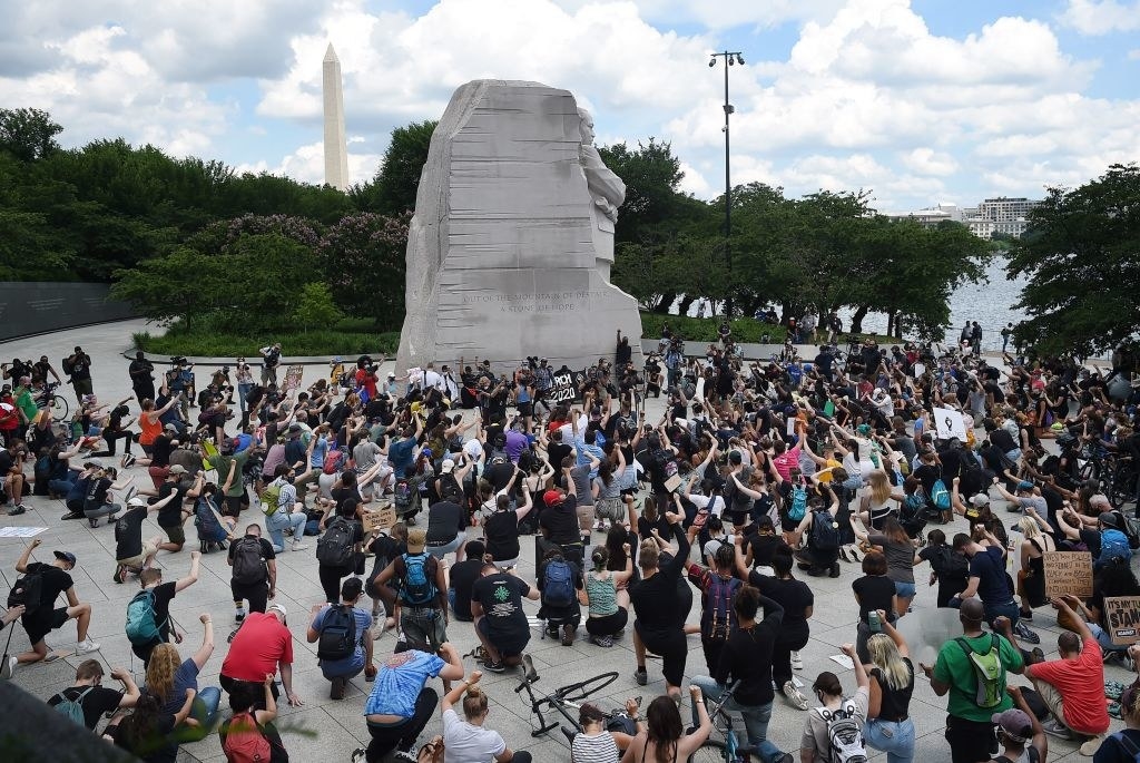 Demonstrators kneel at the Martin Luther King Jr. Memorial