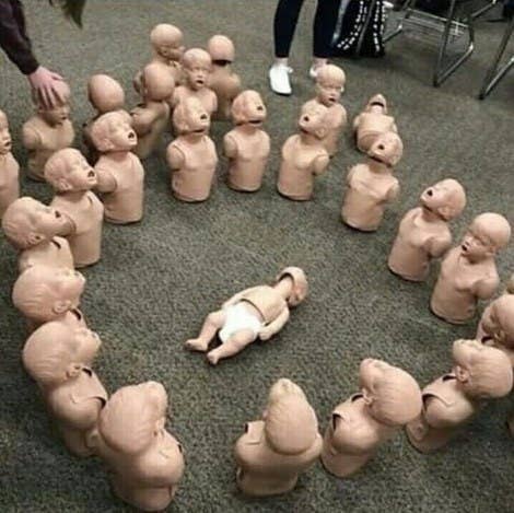 A circle of baby doll torsos surround a king baby doll